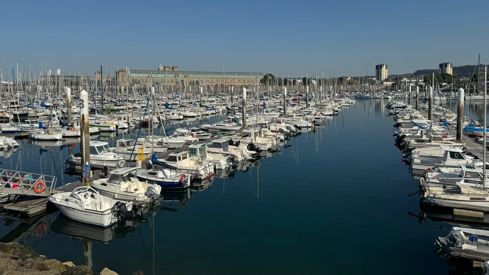 Les pontons du port Chantereyne à Cherbourg, avec au fond la longue toiture verte de l'ancienne gare maritime transatlantique