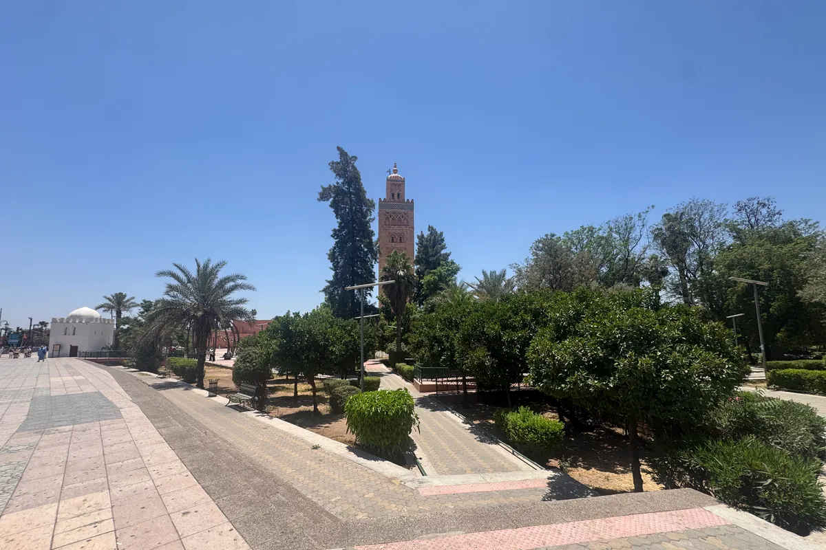 Le jardin et les allées devant la Koutoubia, avec à gauche la petite koubba blanche de Lalla Zohra (juin 2026)