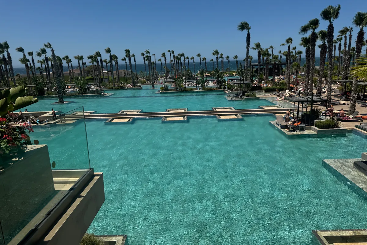 Las piscinas turquesa del hotel, en cascada entre palmeras y tumbonas, con el océano al fondo (mayo de 2026)