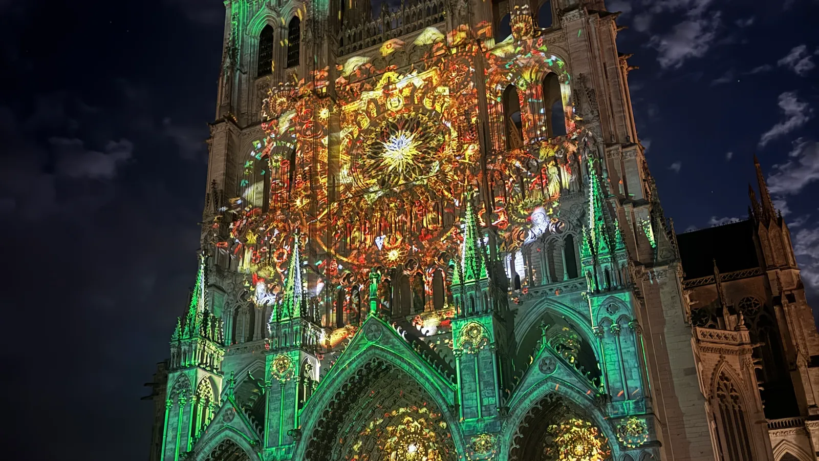 La façade de la cathédrale d'Amiens colorée en vert et or pendant le spectacle Chroma