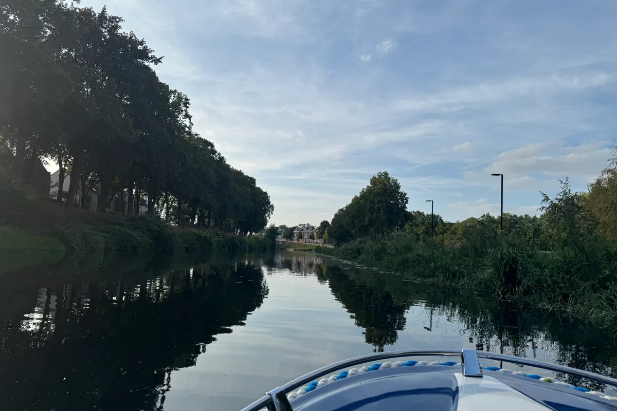 Un bras d'eau bordé d'arbres, depuis l'avant du bateau (août 2026)