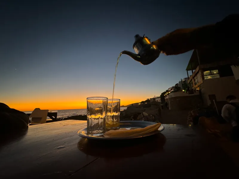 Thé à la menthe servi en terrasse face à l'océan, au coucher du soleil, Taghazout