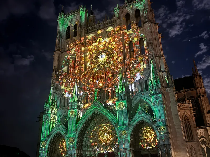 La façade de la cathédrale d'Amiens colorée en vert et or pendant le spectacle Chroma